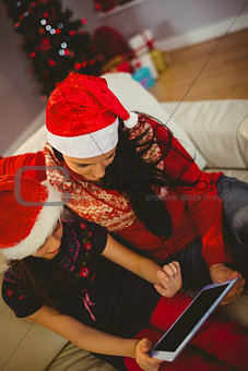 Festive mother and daughter using tablet pc