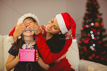 Mother surprising her daughter with christmas gift