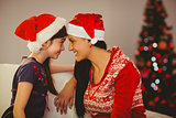 Festive mother and daughter smiling at each other