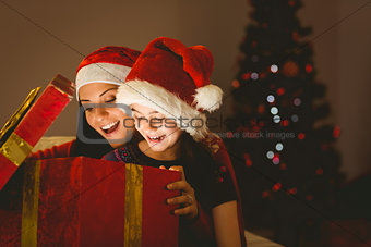 Festive mother and daughter opening a christmas gift