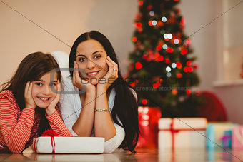 Festive mother and daughter smiling at camera
