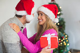 Smiling couple wearing santa hats