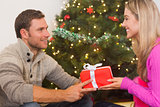 Sitting couple giving each other presents