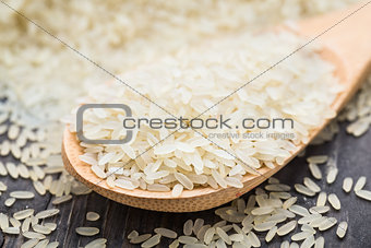 White uncooked rice in a spoon