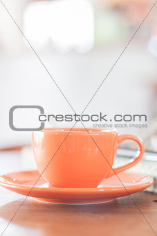 Mini orange coffee cup in coffee shop