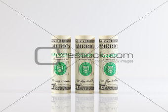 Rolls of dollar bills on a glass table