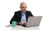 businessman sitting at desk, working on laptop computer