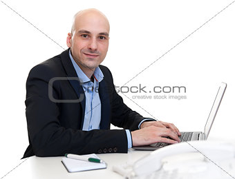 businessman sitting at desk, working on laptop computer