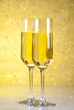 a pair of flutes of champagne on golden abstract background