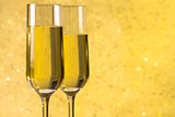 a pair of flutes of champagne golden abstract background