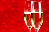 a pair of flutes of champagne red abstract background