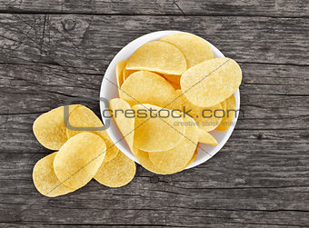 chips in a plate on a wooden background