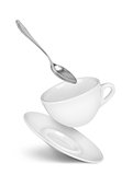 falling cup with saucer and spoon on isolated white background