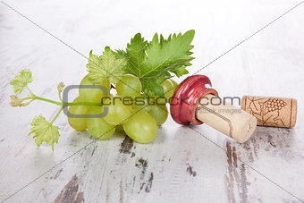 Wine corks, white grapes and wine leaves.