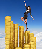 Businesswoman climbing stairs of gold coins