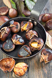 Frying pan with roasted chestnuts closeup.
