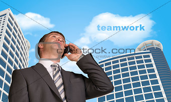 Businessman talking on the phone. Cloud with word teamwork