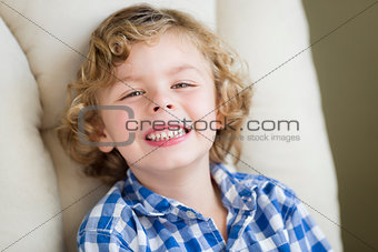 Cute Blonde Boy Smiling Sitting in Chair