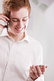 a guy telephoning with two mobiles