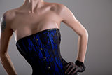 Busty young woman in black and blue corset with floral pattern 