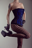 Sexy young woman wearing corset and high heel shoes 