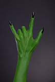 Green monster hand with black nails showing heavy metal gesture 