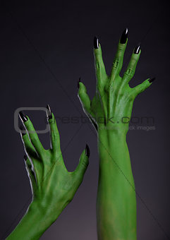 Green monster hands with black nails stretching up, real body-ar