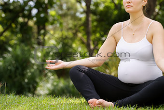 pregnant woman mother belly relaxing park yoga lotus