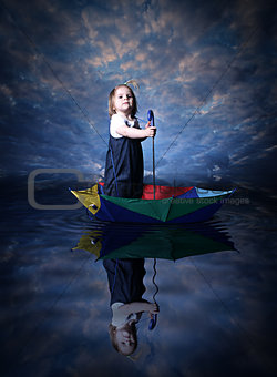Little girl is sailing using the umbrella
