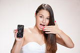 Young woman with broken smartphone.