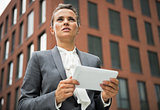 Portrait of serious business woman with tablet pc in front of of