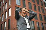 Happy business woman rejoicing in front of office building