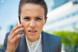 Portrait of business woman talking cell phone in office district