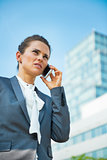 Business woman talking mobile phone in office district