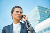Business woman talking mobile phone in office district