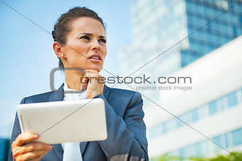 Portrait of thoughtful business woman in front of office buildin