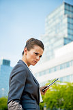 Portrait of serious business woman with tablet pc in office dist