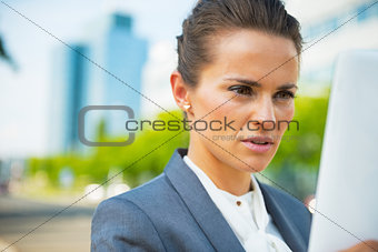 Happy business woman using tablet pc in office district