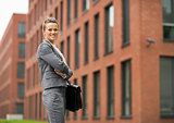 Portrait of smiling business woman in front of office building