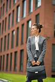 Business woman in front of office building looking on copy space