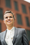 Portrait of smiling business woman in front of office building