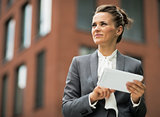 Business woman with tablet pc in front of office building
