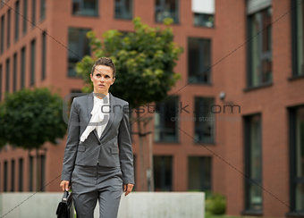Business woman with briefcase walking in business district