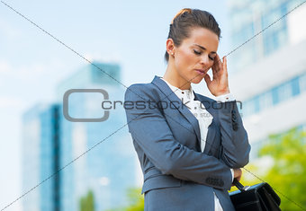 Stressed business woman with briefcase in office district