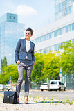 Full length portrait of happy business woman with briefcase in o