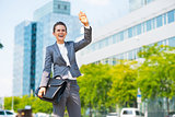 Happy business woman with briefcase in office district greeting