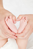 Mother hands holding baby feet.