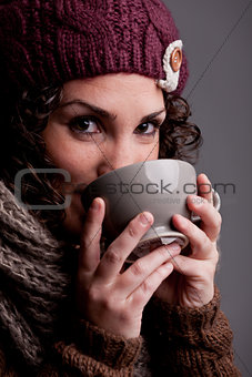 young woman drinks something hot