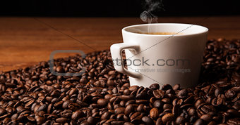 cup of black coffee with roasted coffe beans