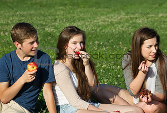 Three Teens Eating Fruit